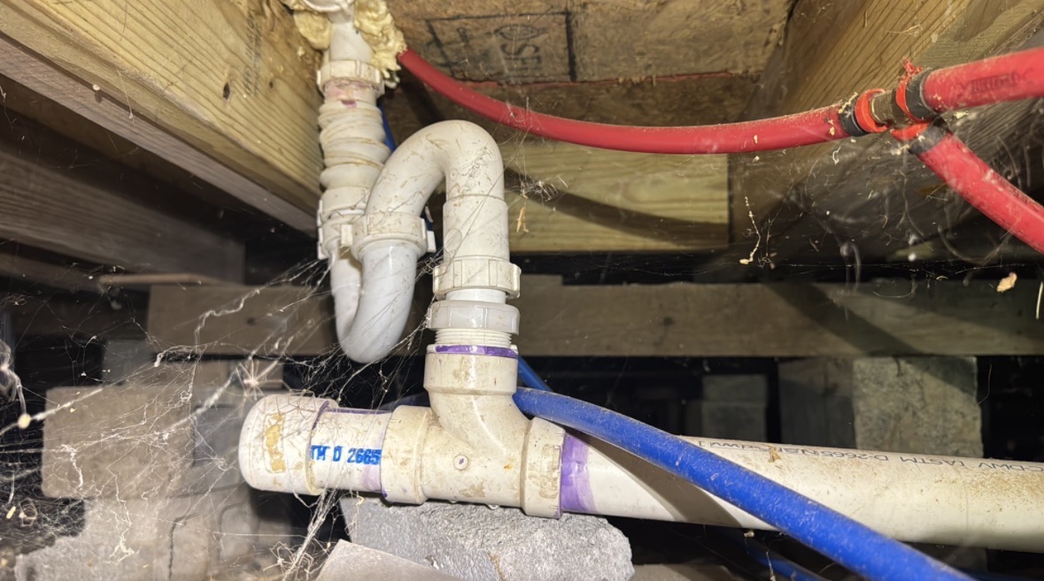 Drain and water lines inspected in a crawl space during a home inspection