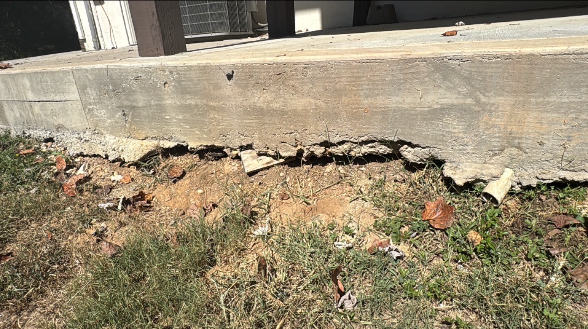 Significant undermining beneath a freshly poured concrete slab at a newly built home