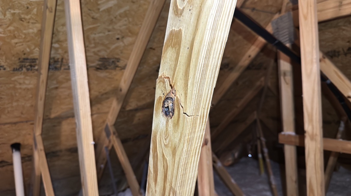 Damaged engineered roof truss in the attic of a newly built home